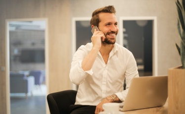 man at laptop on phone