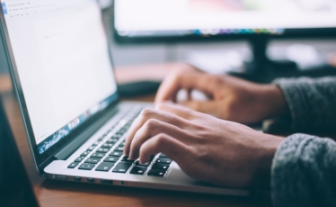 person at laptop keyboard