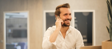man at laptop on phone